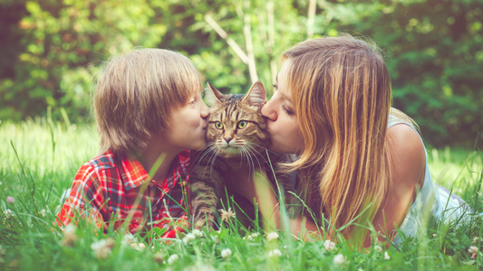 photo of woman and boy loving cat